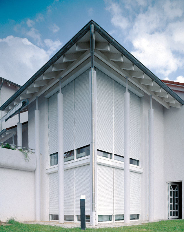 Hausfassade mit vielen Rollläden weiß